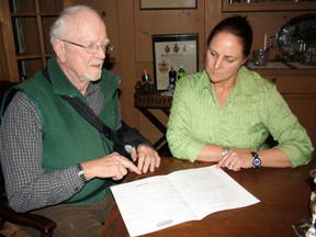 Fred McNutt, left, and his daughter, Jennifer McNutt Bywater, look over some of the paperwork concerning the transfer of Camp Island from the Milne family in 1970 to the province. The family is concerned about the future of the island now part of a land claim.