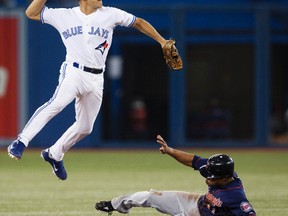 Toronto Blue Jays Omar Vizquel (left) throws the ball to first base over a sliding Minnesota Twins Ben Revere during their Oct. 3, 2012 game. Woodstock and Oxford County will have a chance to show their civic pride and see the revamped Jays May 4 during Woodstock Day when Toronto host the Seattle Mariners.