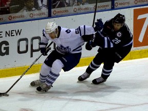 Mike Kostka (left) battles for the puck during a game with the AHL's Marlies. His hard work and patience has finally paid off, as he debuted on home ice with the Maple Leafs on Monday night against the Buffalo Sabres. (DAVE THOMAS/TORONTO SUN)