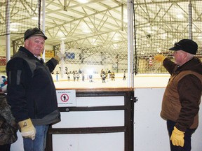 John Blake and Clem Armstrong demonstrate a sample of the transparent arena netting that will soon surround the ice arena.