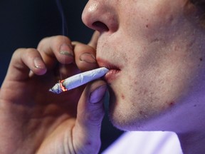 Russell Diercks smokes a half marijuana and tobacco joint inside of Frankie Sports Bar and Grill in Olympia, Washington December 9, 2012.  (REUTERS/Nick Adams)