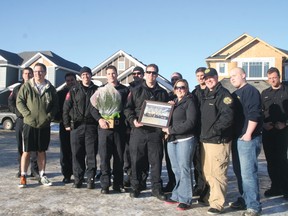 Doug Phaneuf, left, stands with firefighters who helped his family move.