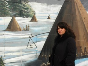 Lyndsay Lindberg stands near a mural depicting Aboriginal people in days gone by in Stony Plain. Lindberg says that she was able to recently reconnect to her Cree culture through the Idle No More movement.