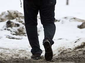 A man walks across 96 Street in the Ritchie neighbourhood in Edmonton Alta., on Friday Jan. 18, 2013. Warm weather turn to colder, more seasonal temperatures over the weekend. Ian Kucerak/Edmonton Sun/QMI Agency