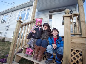Shelley Fox and her son Sam, eight, and Ava, six, sit on the front porch of their brand new house, in Bath. The home was one of two built by Habitat For Humanity Kingston and the many volunteers who spent hours constructing the buildings since spring 2012.      Meghan Balogh - Napanee Guide