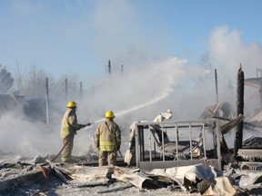 Volunteer firefighters extinguish hot spots at a Dowling barn fire on Thursday. JOHN LAPPA/THE SUDBURY STAR/QMI AGENCY