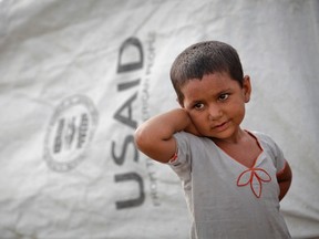 A Pakistani girl displaced by heavy flooding stands outside a tent donated by USAID. The American aid agency has much experience cooperating with the private sector, and the Canadian International Develoment Agency can learn from its experience as Canada's aid policy moves in a similar direction