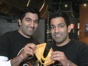 Brothers Rahim, left, and Aly Moloo with a grilled cheese sandwich at their Princess Street restaurant MLTDWN. (Ian MacAlpine The Whig-Standard)