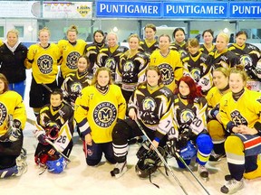 The St. Michael Warriors girls hockey team coached by Mark Flanagan, back right, pose for a photo with one of their opponents during an 11-day trip to Europe over the Christmas holidays...Contributed photo