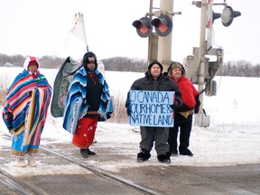A group of four protesters stand along the edge of Highway 16 during an Idle No More protest which also blocked a busy CN Rail line, Wednesday. (QMI Agency/ROBIN DUDGEON)