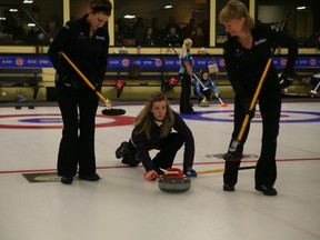 Thornhill Bayview skip Julie Hastings releases a shot while lead Katrina Collins, left, and second Stacey Smith prepare to sweep during her eighth-round game against Marlo Dahl of Thunder Bay Port Arthur at the Ontario Scotties Tournament of Hearts Friday at the K-W Granite Club. Hastings won 8-3 to secure at least a tiebreaker spot with one round-robin draw left. (STEVE GREEN/The London Free Press)