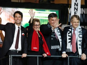 Leadership candidate Kathleen Wynne stands with her camp after the second ballot, with support from candidates who withdrew from the race Eric Hoskins, left, Charles Sousa, second from the right, and Gerard Kennedy, right, at the Ontario Liberal leadership convention on Saturday. (Mark Blinch/Reuters)
