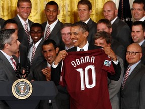 U.S. President Barack Obama receives a jersey from Colorado Rapids Managing Director Jeff Plush during an event honoring the Major League Soccer championship team for their 2010 season and their MLS Cup victory at the White House in Washington June 27, 2011.  (REUTERS/Kevin Lamarque)