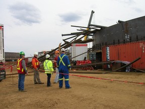 Provincial and CNRL workers inspect the site of a collapsed roof at a tank farm at CNRL's Horizon site in 2007. The collapse killed two temporary foreign workers from China. Supplied Image