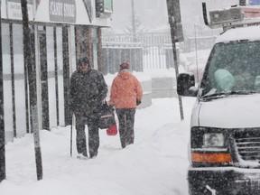 People walk down a snow-covered street in Sudbury on Jan. 28, 2013. With 15 cm of snow expected, cops are warning to be extra cautious on area streets, sidewalks and highways.