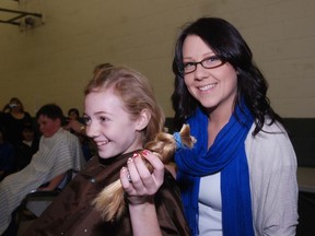 Leah Girardin, left, holds her ponytail she had cut off Saturday at a day-long fundraiser for both James Dunn Wallacetown ChildCan, held at the Dutton/Dunwich Community Centre.