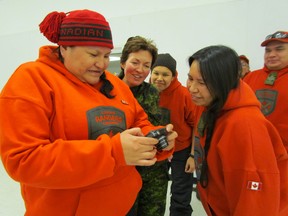 Col. Jennie Carignan, second from left, joins in the laughter as Canadian Rangers in Peawanuck look at photographs on a digital camera. Carignan recently spent a four-day visit in Northern Ontario.