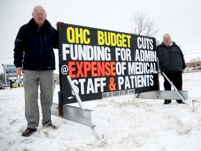 Fred Kuypers and Doug Whitney erected a sign on Dundas Street West in Trenton, saying proposed QHC cuts are being done at the expense of services and medical staff.
Emily Mountney/Trentonian/QMI Agency