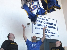 Bert Church athletic director Mike Sera tosses the school’s sports uniforms into the air while gym teachers Andy Kirk, left, and Carol Smith, right, look on. The school won the $100,000 Finding Undeniable contest and will use some of the money to replace the uniforms.
TESSA CLAYTON/AIRDRIE ECHO