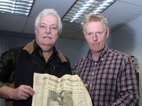 Utilities Kingston director of water & wastewater operations Kevin Riley and president and CEO Jim Keech hold a some items, including a copy of the Kingston Whig-Standard from Dec. 20, 1957, that was found in a time capsule at the River Street pumping station. (Ian MacAlpine The Whig-Standard)