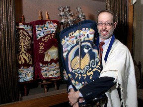 Rabbi L. Shalom Plotkin at the Beth Israel Synagogue on Tuesday with one of the synagogue's Torahs. (Ian MacAlpine The Whig-Standard)