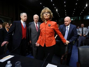 Former U.S. Rep. Gabrielle Giffords is assisted by her husband, retired U.S Navy Captain Mark Kelly (R) prior to a Senate Judiciary committee hearing on gun violence, on Capitol Hill in Washington January 30, 2013. The hearing comes six weeks after the massacre of 26 people at a Connecticut school ignited new calls to fight gun-related violence. Committee Chairman Patrick Leahy (2ndL) (D-VT) and Charles Grassley (R-IA) look on at left. REUTERS/Kevin Lamarque