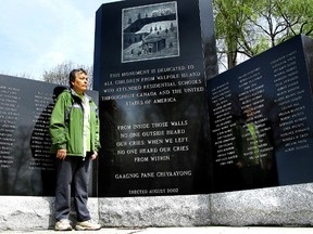 Susie Jones, one of several members of the Walpole Island First Nation community who is a survivor of the residential school system, stands near a monument. (QMI Agency)