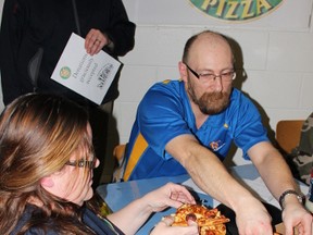 Tara Muntain (left) and Lloyd Muntain weigh the pizza after the pizza eating contest on Tuesday, January 29, 2013.