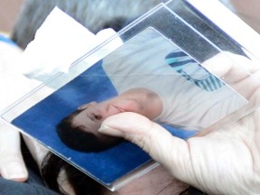 Kim Thomas holds a picture of her son Brandon while hugging her daughter Kayla after a disappointing day in court on Jan. 24 in Cochrane.