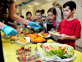 Chaela Chantler, 7, reacts to the watermelon placed on her plate, while she moves along the salad line with classmate Lucas Eddington, far right, at Tecumseh Public School. The pilot program provides a selection of fruit, vegetables, meat, or meat alternative and cheese to students once a month. Photo taken Chatham, On., Wednesday January 30, 2013. DIANA MARTIN/ THE CHATHAM DAILY NEWS/ QMI AGENCY