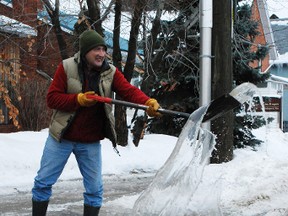 James Stephenson tosses a shovelful of water into the air, demonstrating his disgust at the annual pond that collects in front of his Worthington Street home during January and spring thaws. The sewer drain at the curb gets covered by a snowbank that makes drainage and parking difficult.