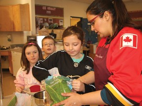 Home economics teacher Amrit Nannan, right, helps Grade 5 student Kyla Lowe make a smoothie while a pair of classmates look on during Family Literacy Day activities at Meadowbrook Middle School.
TESSA CLAYTON/AIRDRIE ECHO