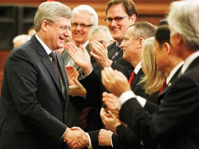Canada’s Prime Minister Stephen Harper, left, shakes hands before delivering a speech during a Conservative caucus meeting on Parliament Hill in Ottawa Wednesday.
REUTERS/CHRIS WATTIE