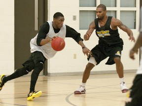Karron Clarke, one of two new players at London Lightning practice Wednesday, drives on Jeremy Williams at the Central YMCA on Wednesday. (CRAIG GLOVER The London Free Press)