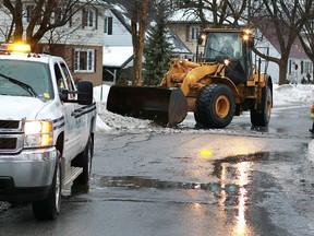 Ottawa city crews keep the storm drains open on Hutton Ave. Thursday, Jan. 31, 2013. Mild temperatures along with rain caused flooding in some areasover night. Tony Caldwell/Ottawa Sun