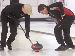 Miles Nystrom, left, and Brett Zubot keep Jason Hardy's rock on target during the 'A' final of the Cochrane Men's Bonspiel, Jan. 27.