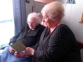 Kathleen McFie, left, turned 100 on Tuesday and looks at a birthday card with her daughter Faye Asselstine.