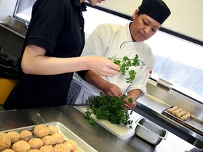 Lana Chevrier, right, a third-year culinary student, and Sarah Bi, an exchange student from Beijing, prepare a parsley garnish near a tray of mushroom caps for a catered dinner Thursday afternoon for Thursday's Pub and Grill student-run restaurant at Canadore College. (MARIA CALABRESE The Nugget)