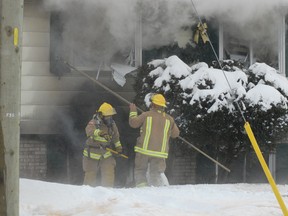 Firefighters break windows to help heat escape from a fire at 36 Arden St. in Sault Ste. Marie on Friday, Feb. 1, 2013.