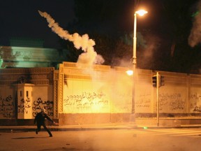 A protester throws a tear gas canister fired by police, towards the presidential palace during clashes between protesters and police in front of the palace in Cairo February 1, 2013.  REUTERS/Asmaa Waguih