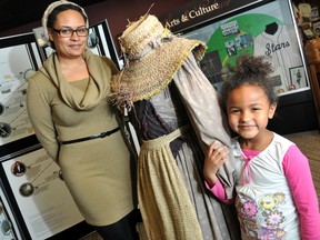 Blair Newby is the Executive Director of the Chatham-Kent Black Mecca Museum, far left, and Olivia Vandenbaerde, 5, stand next to a traditional dressed form representing Chatham-Kent's Black History Connection: Past, Present, Future which kicked off Friday. (DIANA MARTIN, The Chatham Daily News)