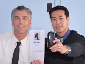 Darren Hansma of INTACTAccess Group, left, with a pamphlet which describes the bail release program involving electronic monitoring. Steve Tan, of Recovery Science Corporation, holds one of the GPS/cellular ankle bracelets he supplies to INTACTAccess.