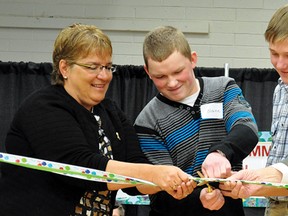 The ribbon cutting marking the official re-opening of Arrowwood Community School was a bit more difficult than expected, as Palliser trustee Colleen Deitz, students Blaine Cockwill and Abraham Dyck, and Palliser board chair Don Zech struggle to cut the ribbon with the scissors provided. To much laughter, they eventually did cut the ribbon after considerable effort.