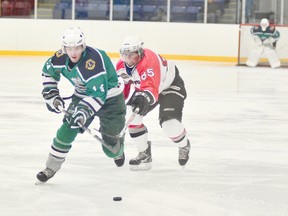 Welland Whalers forward Chris Downey, foreground, is hooked by an Orillia Tundras defender in senior A hockey Saturday night at Welland Arena. JOE CSEH Tribune Photo