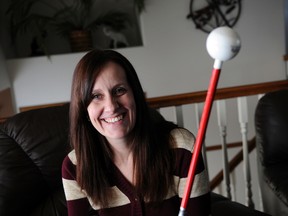 Bobby Weir, who is legally blind, holds a white cane in her home on Friday. Weir is hoping that White Cane Awareness Week will help to solve some issues, such as unshovelled sidewalks, which cause problems for visually impaired people. (Adam Jackson/Daily Herald-Tribune)