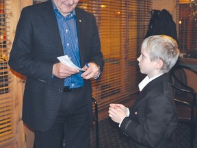 Liberal leadership hopeful and former astronaut Marc Garneau signs an autograph for young Josiah Dondo from St. Claude during a meeting with supporters in Portage la Prairie Sunday afternoon. (CLARISE KLASSEN/PORTAGE DAILY GRAPHIC)