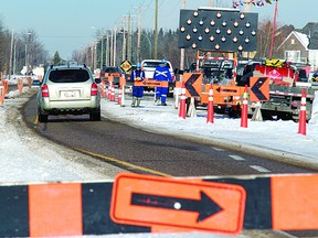 Construction crews signal for traffic to slow down. File Photo.