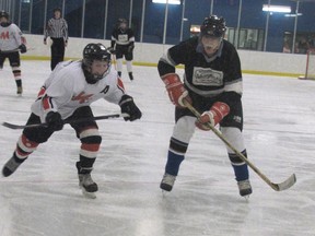 Brad Adams, left, a Grade 6 student, and teacher Stan Lucas race for the puck at Mayerthorpe Exhibition Centre in the annual Elmer Elson Elementary School Staff-Student Hockey Game on the evening of Thursday, Jan. 31. The game  concluded in a 7-7 tie. See pages 14, 15 for more photos.