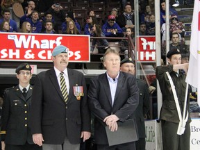 Jerry Brooks, front left, stands with Bill Abercrombie, Sarnia Sting VP of hockey operations, at a Jan. 17, 2013 game at the RBC Centre in Sarnia, Ont. The retired Canadian Forces sergeant is one of several military personnel honoured as part of the Sting's Veteran's Way program this season. PAUL OWEN/THE OBSERVER/QMI AGENCY