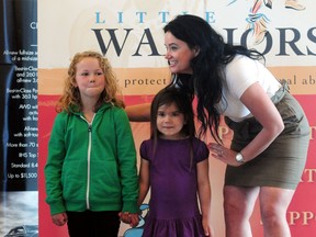 Little Warriors founder Glori Meldrum stands beside a pair of girls at a Little Warriors press conference last year. FILE PHOTO